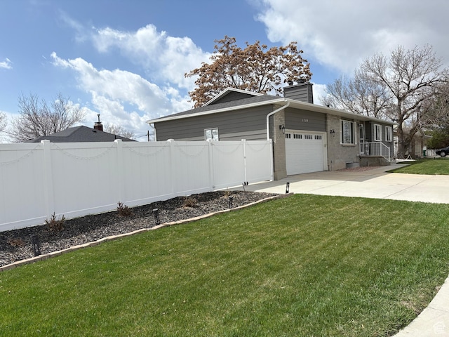 view of property exterior with fence, driveway, a garage, a yard, and a chimney