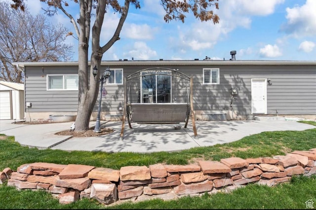 rear view of property featuring an outbuilding, crawl space, a garage, and a patio