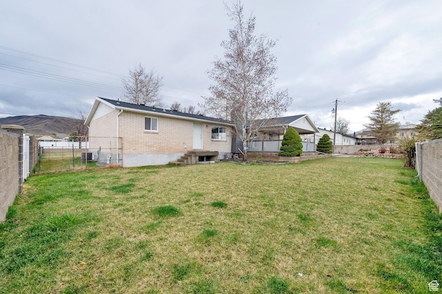 6102 W 13400 S, Herriman, UT 84096 - rear view of property with cooling unit, a fenced backyard, entry steps, brick siding, and a yard