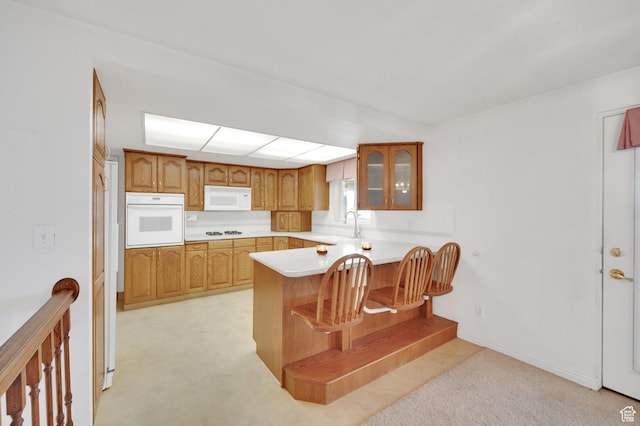 6102 W 13400 S, Herriman, UT 84096 - kitchen featuring light countertops, white appliances, a sink, a peninsula, and glass insert cabinets