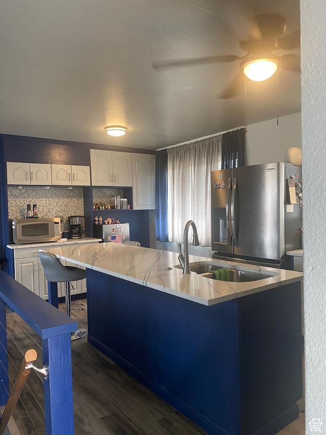 6489 W Castle View Dr S, West Valley City, UT 84128 - kitchen featuring light stone countertops, stainless steel appliances, white cabinets, decorative backsplash, and dark wood-type flooring