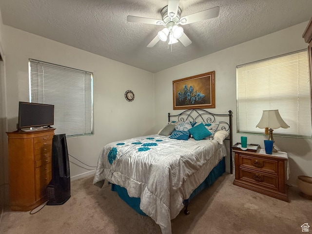 bedroom featuring ceiling fan, carpet floors, and a textured ceiling