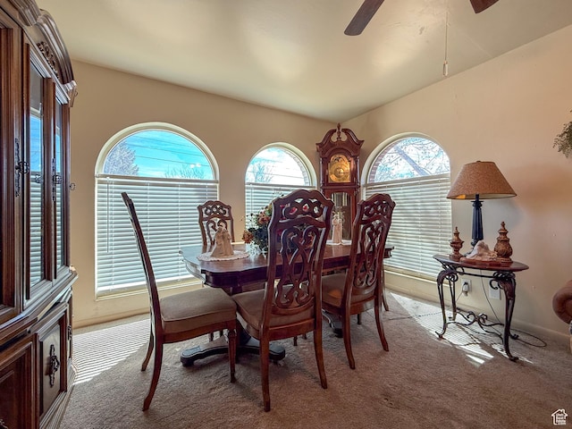 carpeted dining space with a ceiling fan