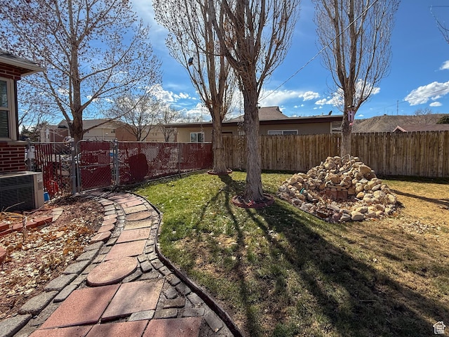view of yard with a gate, central AC, and fence private yard