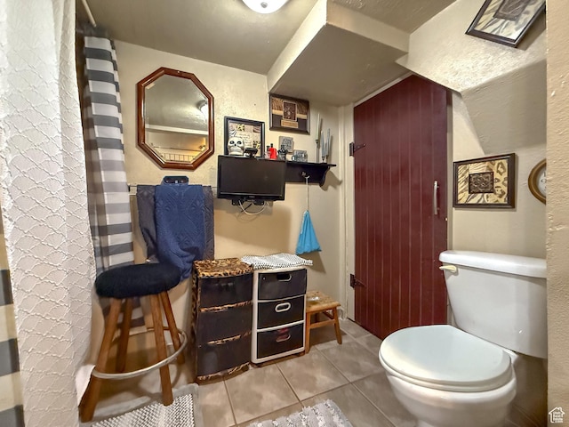 bathroom featuring toilet and tile patterned flooring