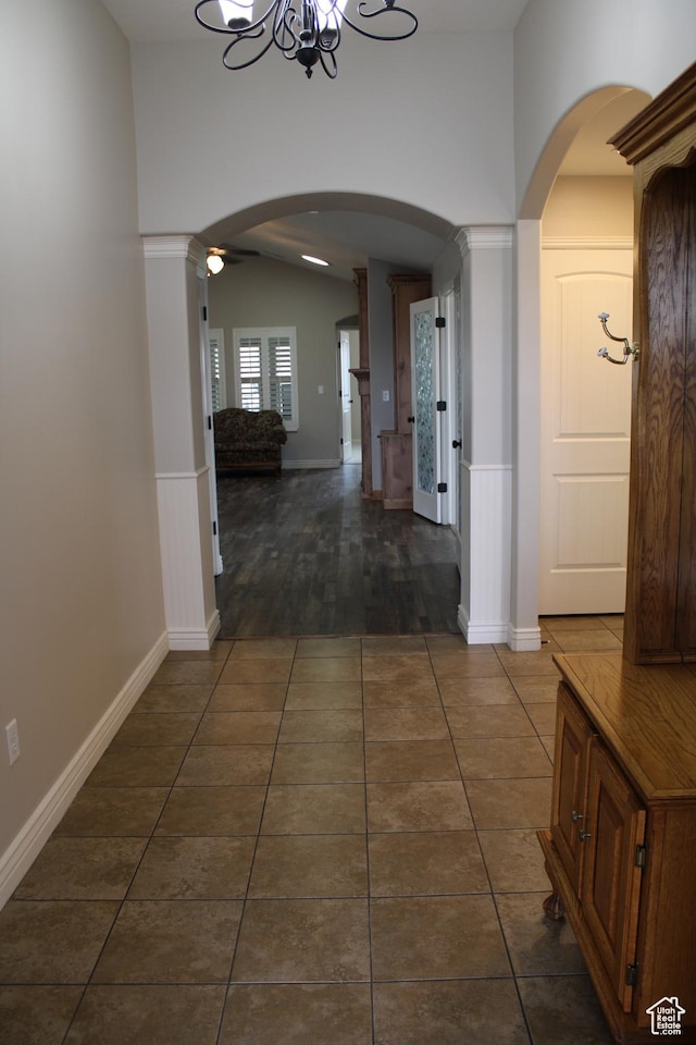 1660 N 475 E, North Ogden, UT 84404 - hallway with vaulted ceiling, an inviting chandelier, dark tile patterned floors, arched walkways, and wainscoting