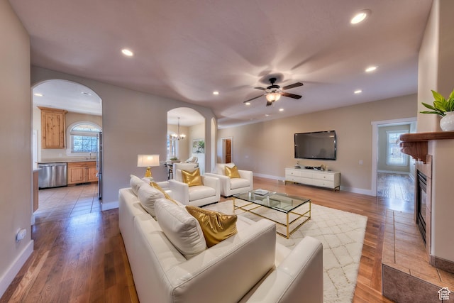 494 E Kachina Way, Moab, UT 84532 - living room with light wood-style flooring, arched walkways, a glass covered fireplace, and recessed lighting