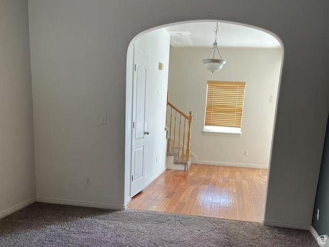 890 E Chase Brook Ln S, Millcreek, UT 84107 - carpeted empty room with arched walkways, stairs, baseboards, and wood finished floors