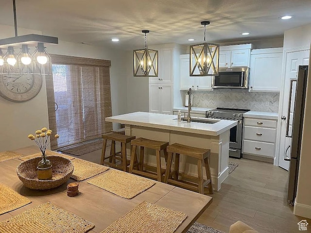 3155 S Hidden Valley Dr Unit 331, St George, UT 84790 - kitchen with light countertops, stainless steel appliances, white cabinetry, a sink, and an inviting chandelier