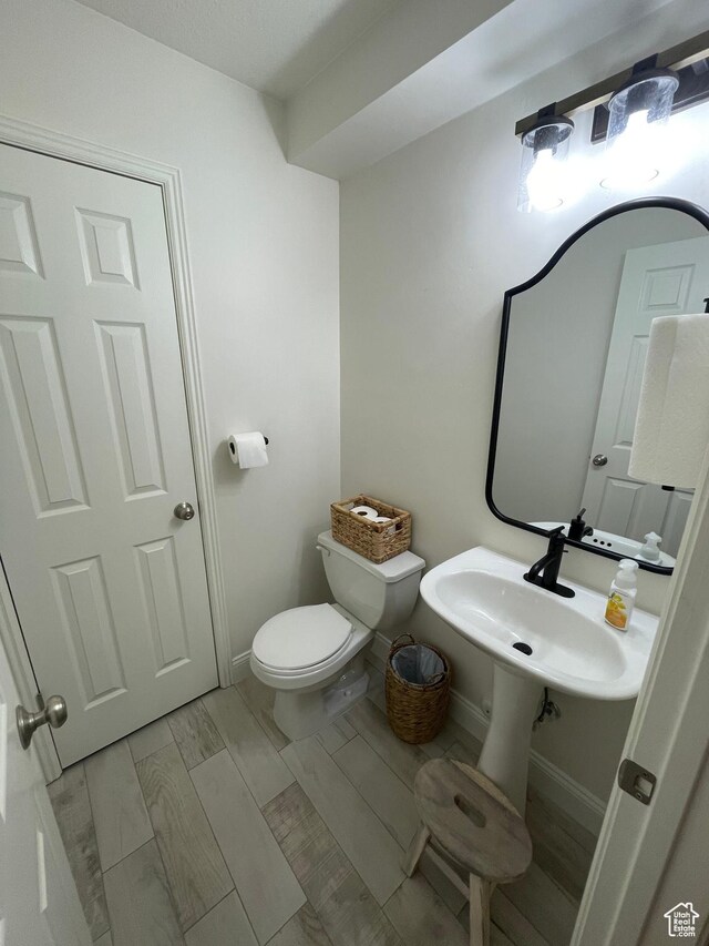 3155 S Hidden Valley Dr Unit 331, St George, UT 84790 - bathroom featuring wood tiled floor, toilet, baseboards, and a sink