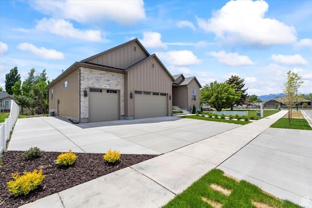 1065 W 125 S, Lehi, UT 84043 - view of front of property featuring board and batten siding, a garage, concrete driveway, a front lawn, and cooling unit