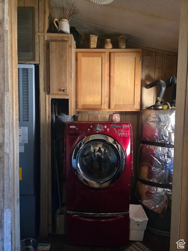 clothes washing area featuring a heating unit, washer / clothes dryer, and cabinet space
