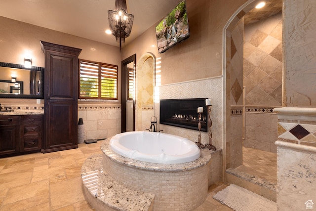 4757 Hidden Lake Dr, Bountiful, UT 84010 - full bathroom with stone tile floors, a walk in shower, vanity, a bath, and tile walls