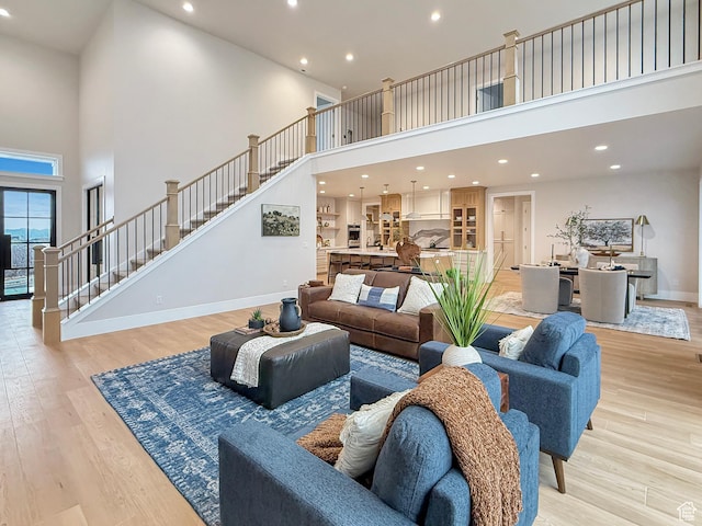 4014 N Dillon Way N, Ogden, UT 84414 - living room with baseboards, a towering ceiling, stairway, and light wood finished floors