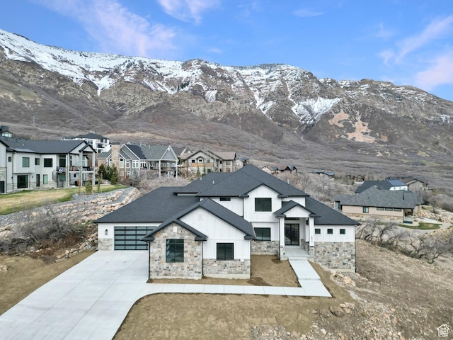 4014 N Dillon Way N, Ogden, UT 84414 - view of front of house featuring stone siding, roof with shingles, concrete driveway, a residential view, and a mountain view