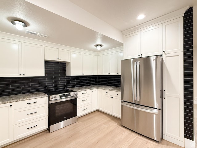 4014 N Dillon Way N, Ogden, UT 84414 - kitchen with tasteful backsplash, light wood-type flooring, visible vents, white cabinets, and appliances with stainless steel finishes