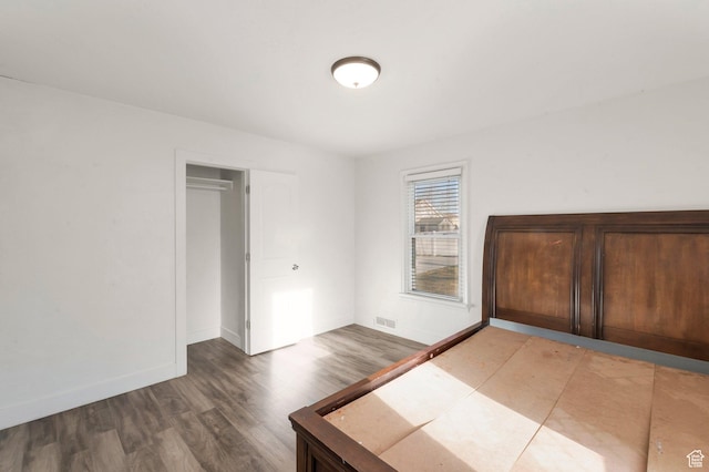 unfurnished bedroom featuring visible vents, baseboards, and wood finished floors