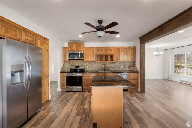 kitchen with visible vents, a center island, appliances with stainless steel finishes, a sink, and backsplash