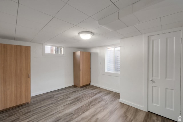 basement with plenty of natural light, baseboards, and wood finished floors