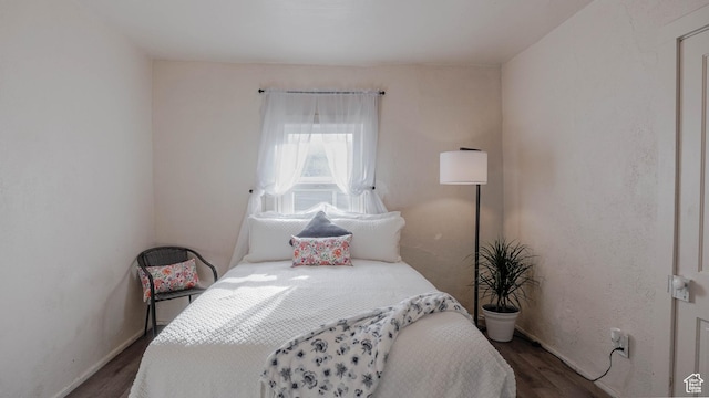 bedroom featuring dark wood-style flooring and baseboards