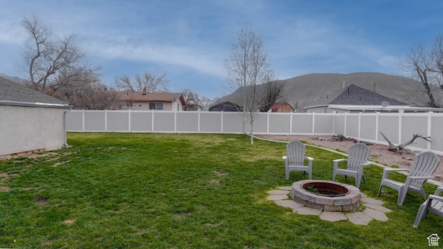 view of yard with a fenced backyard and a fire pit
