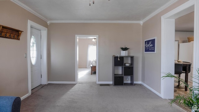 foyer with ornamental molding, carpet, a healthy amount of sunlight, and ceiling fan