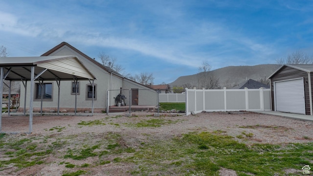 view of yard featuring a garage, fence, and a mountain view