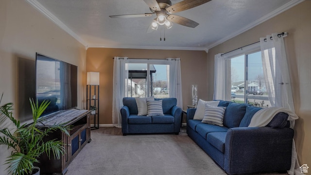 living room with light colored carpet, crown molding, a ceiling fan, and a healthy amount of sunlight