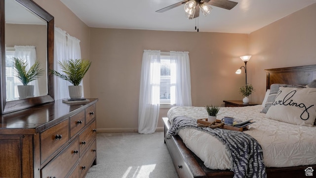 bedroom featuring baseboards, light colored carpet, and ceiling fan