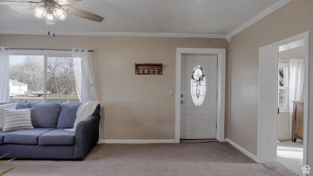 carpeted foyer entrance with baseboards, crown molding, a healthy amount of sunlight, and a ceiling fan
