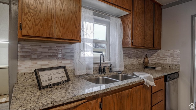 kitchen with dishwasher, a sink, brown cabinets, and decorative backsplash