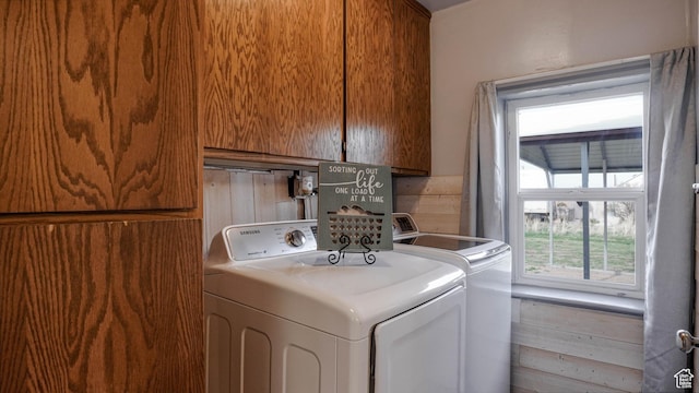 washroom featuring cabinet space and washer and clothes dryer