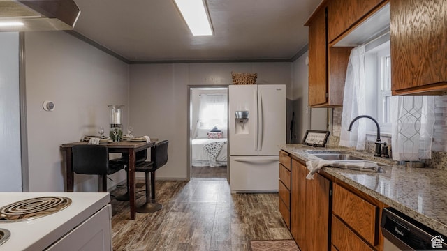 kitchen featuring a sink, dishwashing machine, white fridge with ice dispenser, and brown cabinets