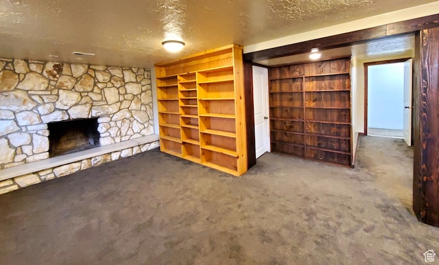 unfurnished living room featuring carpet floors, a fireplace, and a textured ceiling