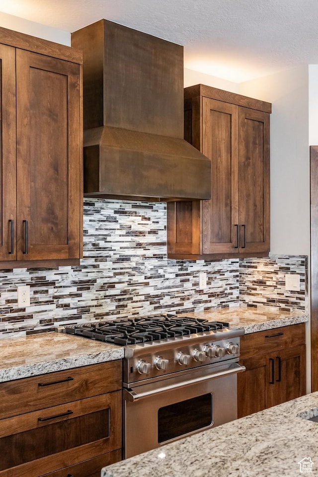 853 W Benjamin Pl, Kamas, UT 84036 - kitchen with light stone countertops, high end stainless steel range, wall chimney range hood, and tasteful backsplash