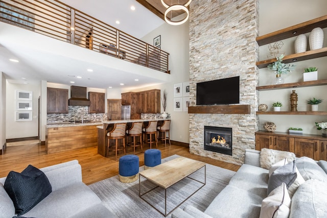 853 W Benjamin Pl, Kamas, UT 84036 - living room with a fireplace, a towering ceiling, light wood-type flooring, and baseboards
