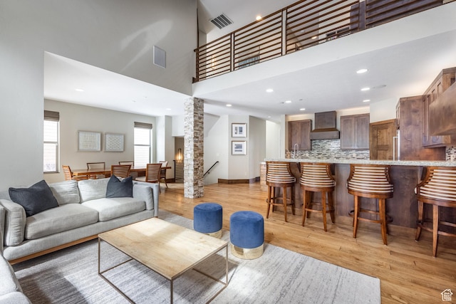 853 W Benjamin Pl, Kamas, UT 84036 - living room with recessed lighting, a high ceiling, light wood-style floors, visible vents, and ornate columns
