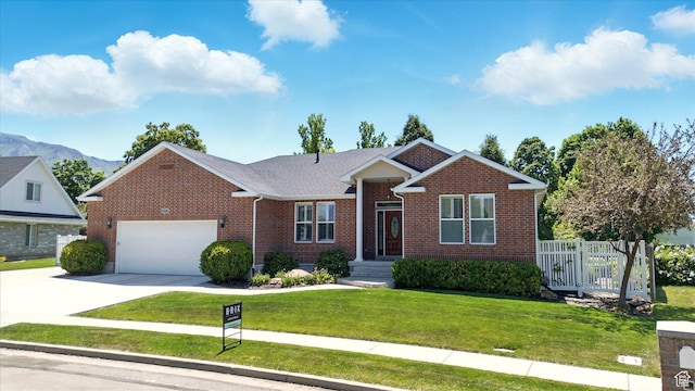 534 E 2000 N, North Logan, UT 84341 - view of front of property featuring brick siding, an attached garage, driveway, a front yard, and a mountain view