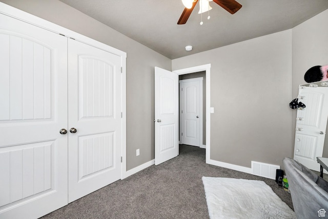 unfurnished bedroom with baseboards, visible vents, a closet, and dark colored carpet