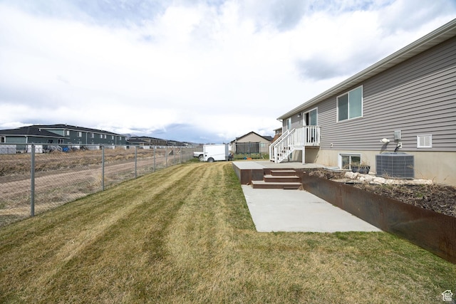 view of yard with a patio area, fence, and central AC
