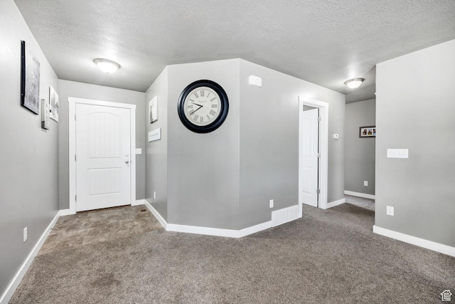 entrance foyer with carpet, baseboards, and a textured ceiling