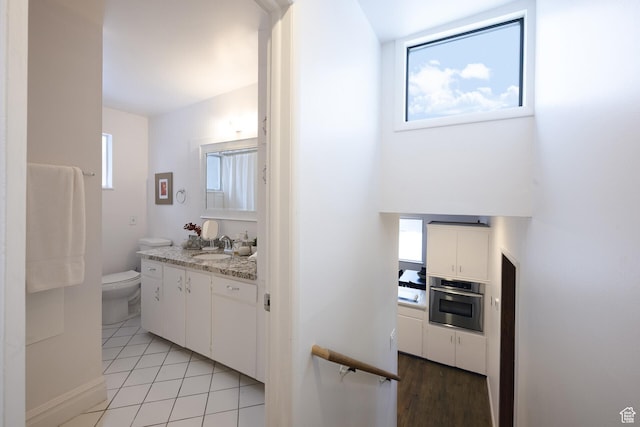 bathroom featuring tile patterned floors, vanity, and toilet