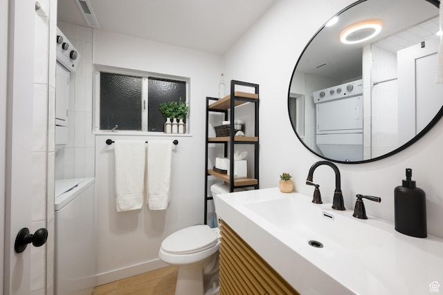 bathroom with washer / clothes dryer, visible vents, toilet, and wood finished floors