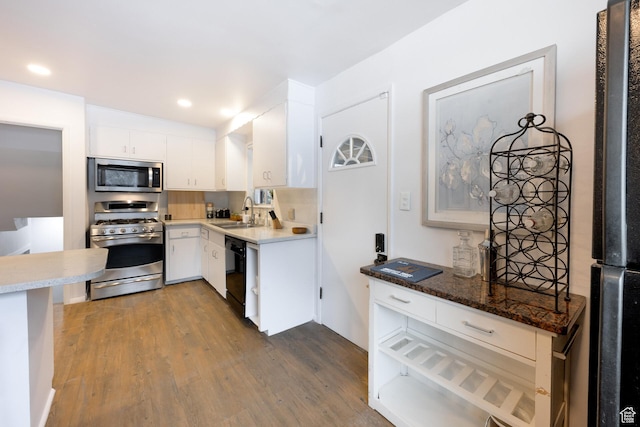 kitchen with recessed lighting, dark wood-style floors, white cabinets, black appliances, and a sink