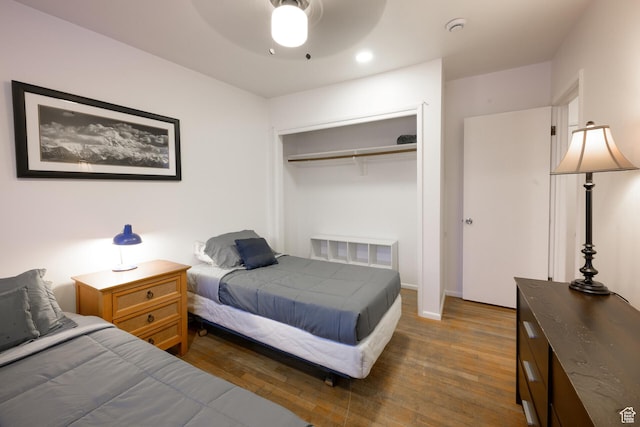 bedroom with a closet, a ceiling fan, and wood finished floors