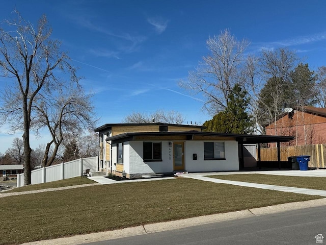 view of front of property featuring driveway, a front lawn, an attached carport, entry steps, and fence