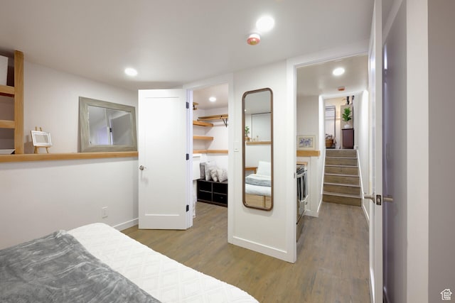 bedroom featuring baseboards, a closet, a spacious closet, recessed lighting, and wood finished floors