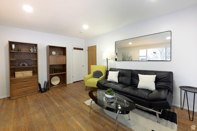 living area with baseboards and wood finished floors