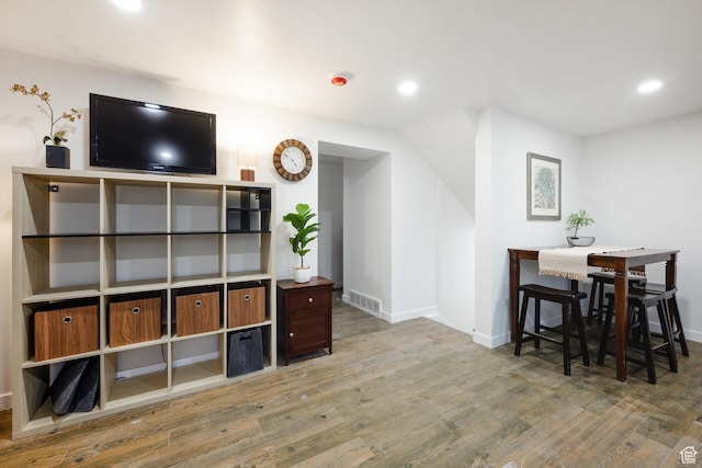 living room featuring visible vents, baseboards, recessed lighting, and wood finished floors