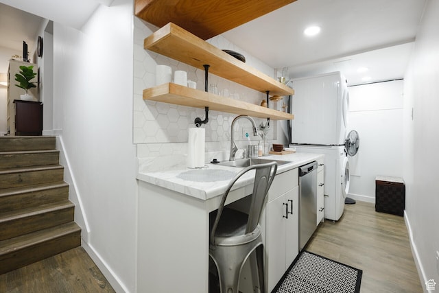 laundry area featuring washer / clothes dryer, baseboards, laundry area, light wood finished floors, and a sink